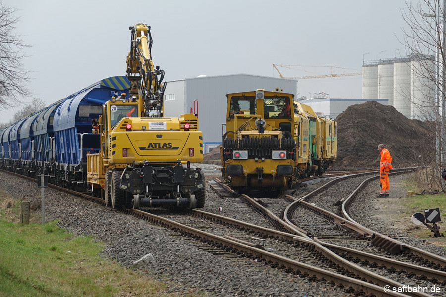 Baumaschinen-Kreuzung in Zörbig: Der Zweiwegebagger, welcher noch Einschotterungsarbeiten vornahm, machte kurzzeitig Platz für die Einfahrt der beiden Großmaschinen in das Anschluss- und Baugleis. 