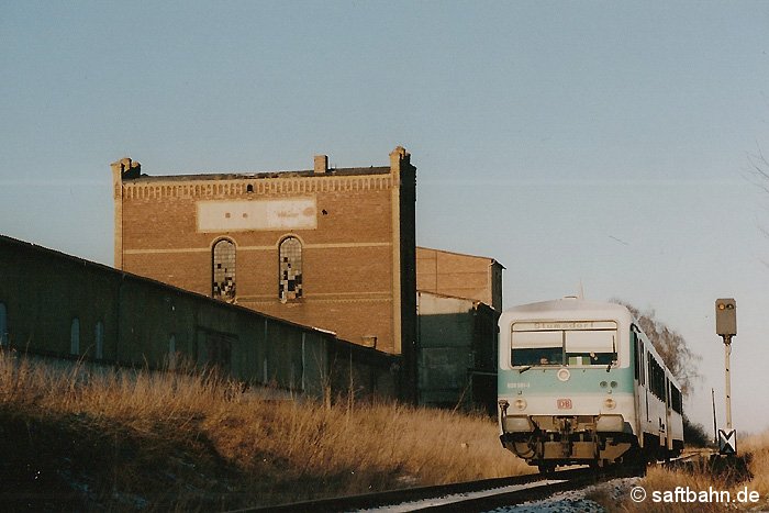 Vorbei am imposanten und filigranen Gebäude der einstigen Zörbiger Kandisfabrik, rollt Triebwagen 628 581 als Regionalbahn 37483 am 23. Januar 2000 bergab den Endbahnhof Stumsdorf entgegen. Vielleicht lassen sich schon bald wieder Bahnbetrieb und Industrierelikt auf Foto bannen; Bemühungen zur Wiederinbetriebnahme des Streckenabschnitts Zörbig-Stumsdorf laufen.